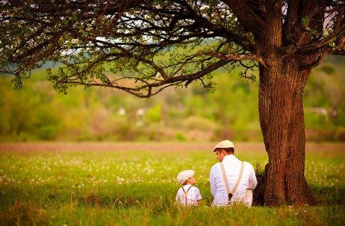 Ojciec i syn rozmawiają pod drzewem