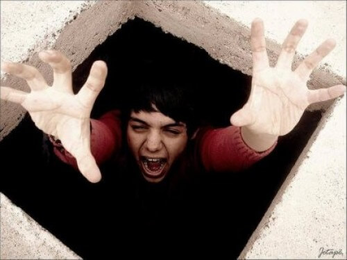 Chłopiec próbuje wydostać się z dziury