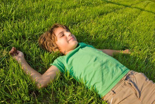 chłopiec leżący na trawie