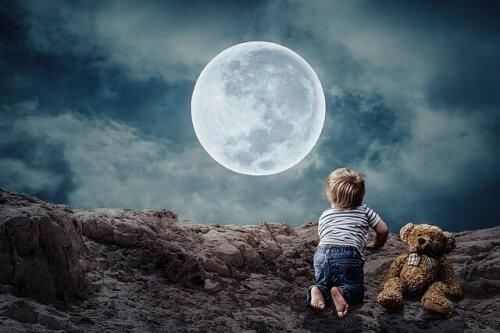 Dziecko i miś patrzą na księżyc