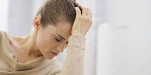 Smutna kobieta trzyma się za głowę