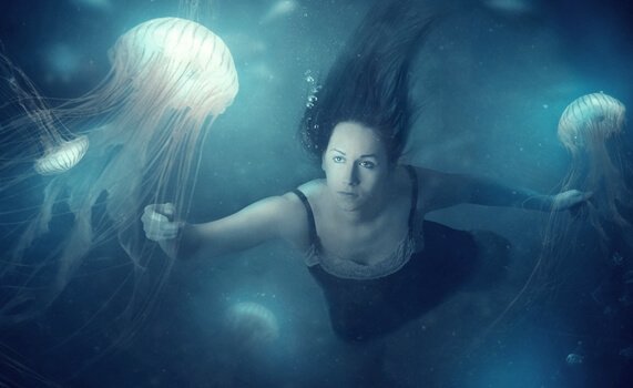 Kobieta pływająca z meduzami