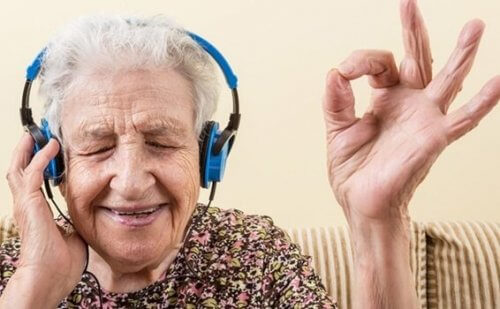 Staruszka słuchająca muzyki - muzyka i śpiewanie sprawia, że jesteśmy szczęśliwi