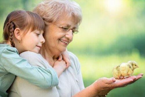 Babcia i wnuczka trzymają pisklę