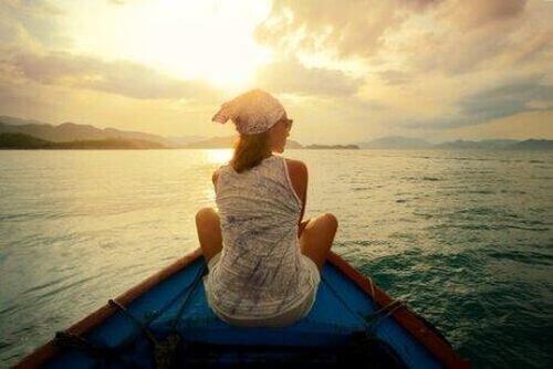 Kobieta siedzi na łódce na środku oceanu