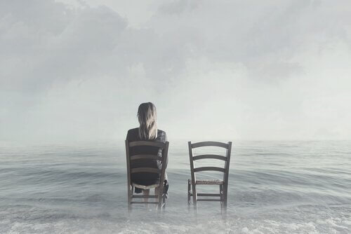Kobieta siedzi na krześle nad morzem