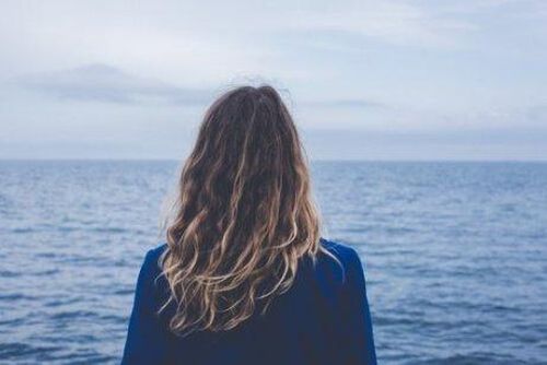 kobieta stoi tyłem i patrzy na ocean