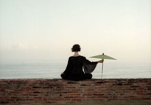 kobieta z parasolką patrząca na morze