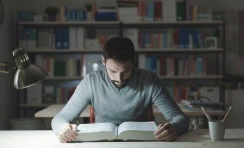 Mężczyzna czyta książkę w bibliotece