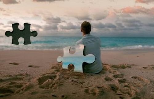 Mężczyzna na plaży z prakującymi puzzlami