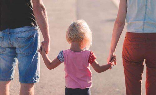 Rodzice trzymają dziecko za ręce
