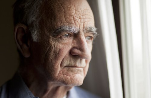 starszy mężczyzna patrzący przez okno