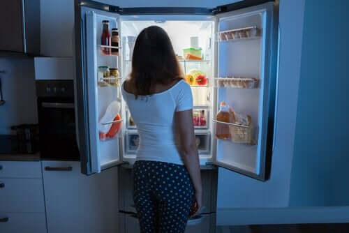 Kobieta jedząca z lodówki w środku nocy