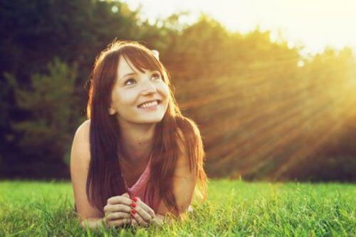 Kobieta na trawie wie, że słońce to lekarstwo na depresję i niepokój