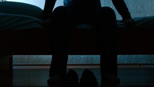 Mężczyzna siedzący na łóżku