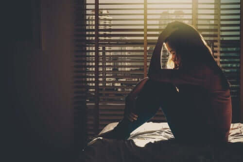 Smutna dziewczyna siedzi na łóżku