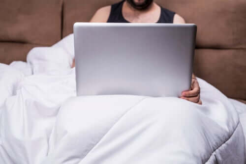 Mężczyzna w łóżku z komputerem