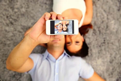 Mężczyzna robiący selfie z kobietą - pragnienie udawania w mediach społecznościowych
