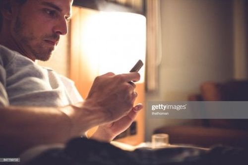 Mężczyzna patrzy w telefon - uzależnienia behawioralne