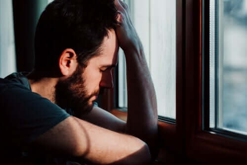 Smutny mężczyzna wyglądający przez okno