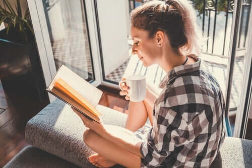 Kobieta czytająca przy balkonie - czytanie poprawia inteligencję emocjonalną