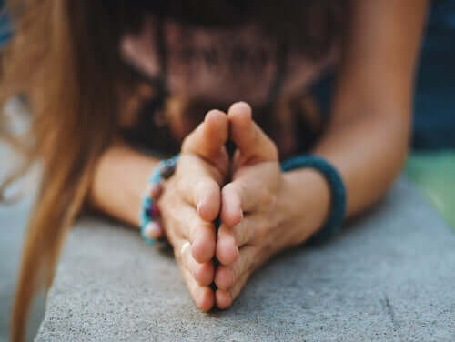 Kobieta ze złożonymi do modlitwy dłońmi