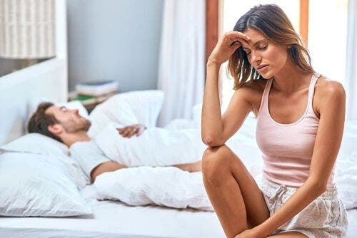 Zmartwiona kobieta siedząca w łóżku - chodzenie spać w złym nastroju