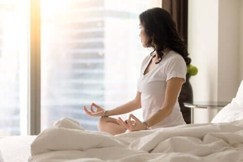 Kobieta medytująca na łóżku - rutyna Miracle Morning