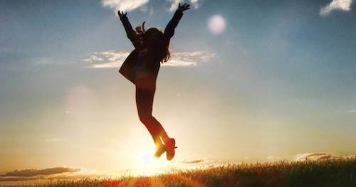 Kobieta skacząca o zachodzie słońca