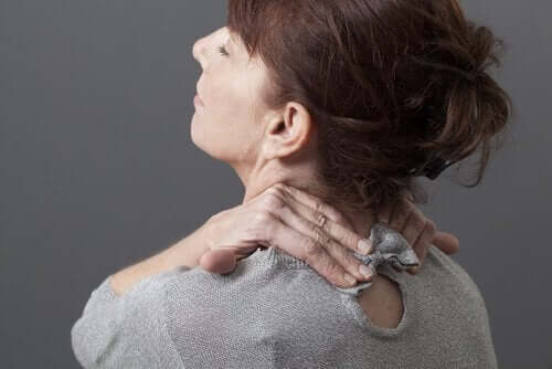 Kobieta chwyta się za kark z powodu bólu szyi