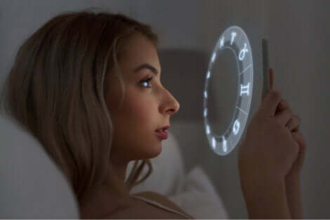 Kobieta czyta horoskop w telefonie - korelacja iluzoryczna