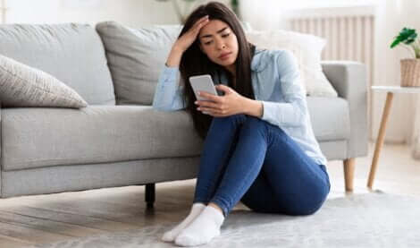 Doomscrolling - kobieta przegląda wiadomości na telefonie i martwi się