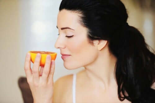 Kobieta wąchająca pomarańcza - uważne jedzenie