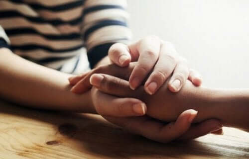 Dwie osoby trzymające dłonie - światu potrzeba więcej współczucia
