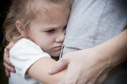 Dziewczynka przytula rodzica z niepokojem na twarzy