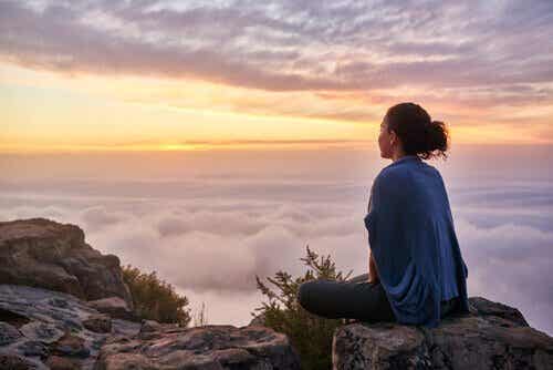 Kobieta siedząca na czubku góry - jak doceniać swój wysiłek?