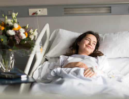 Uśmiechnięta kobieta w łóżku szpitalnym - korzyści płynące z pozytywnego nastawienia