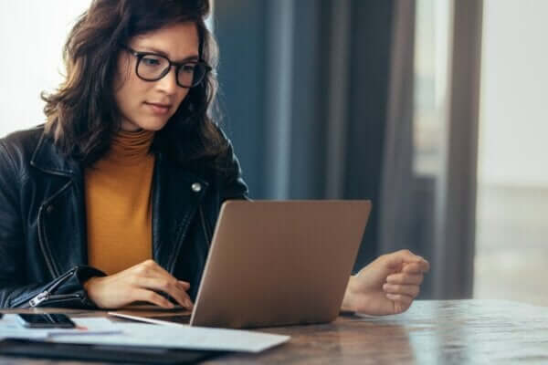 Kobieta pracująca na laptopie, przedstawiająca, jak zarządzać zadaniami w pracy.